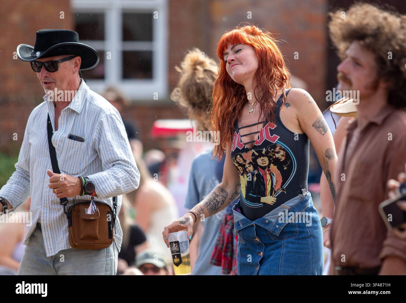 Woman in the audience with beautiful red hair at the19th Maverick long weekend Americana music festival held in Eaton Farm Park in rural Suffolk. Stock Photo