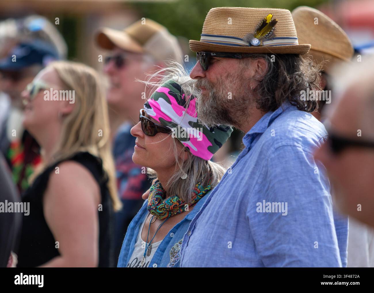 Festival going couple in interesting headgear at the 19th Maverick long weekend Americana music festival held in Easton Farm Park in rural Suffolk. Stock Photo