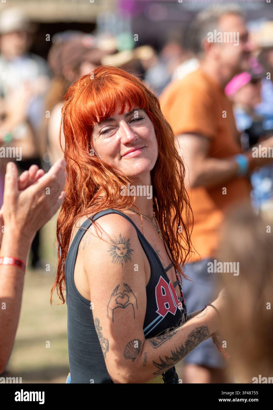 Woman in the audience with beautiful red hair at the19th Maverick long weekend Americana music festival held in Eaton Farm Park in rural Suffolk. Stock Photo
