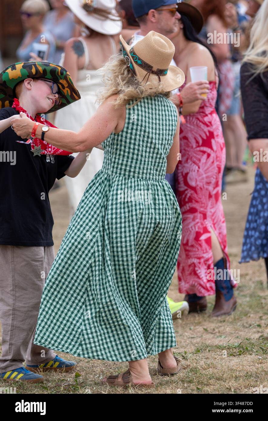 Woman in green gingham and small boy dancing at the 19th Maverick long weekend Americana music festival held in Easton Farm Park in rural Suffolk Stock Photo