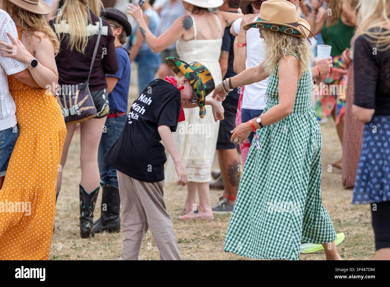 Woman in green gingham and small boy dancing at the 19th Maverick long weekend Americana music festival held in Easton Farm Park in rural Suffolk Stock Photo