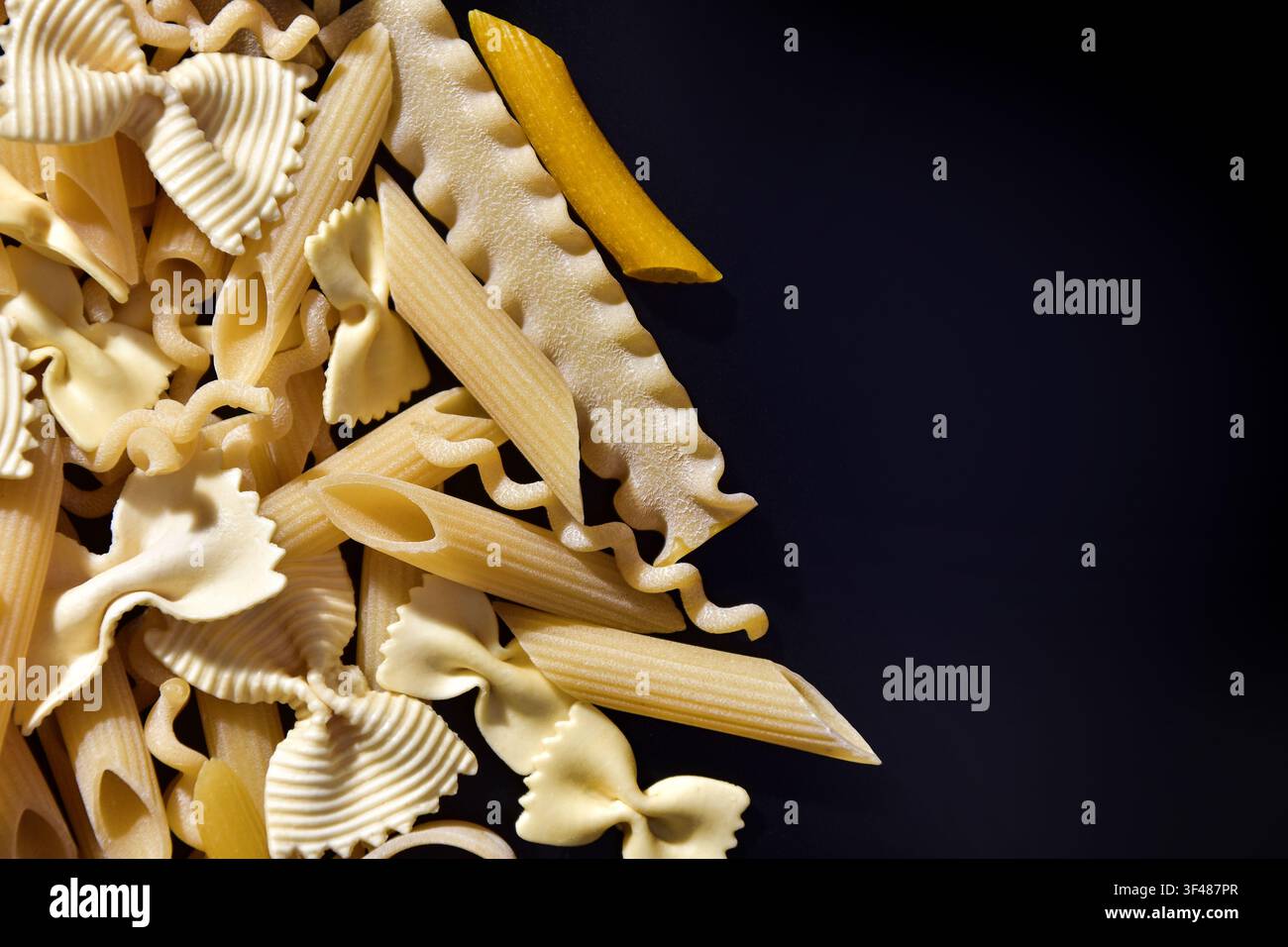Different types of pasta on black background Stock Photo
