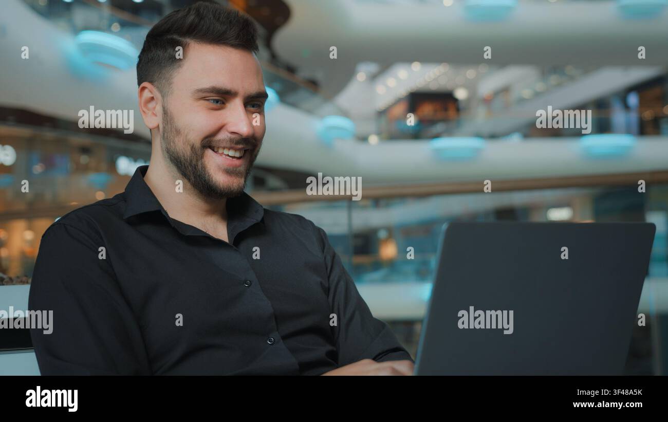Smiling happy Caucasian businessman talking video call with laptop in business center man male guy employer worker talk conference with computer Stock Photo