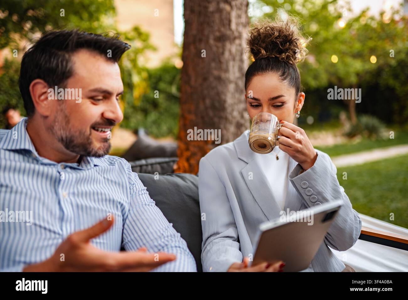 Business colleagues discussing project ideas using digital tablet outdoors Stock Photo