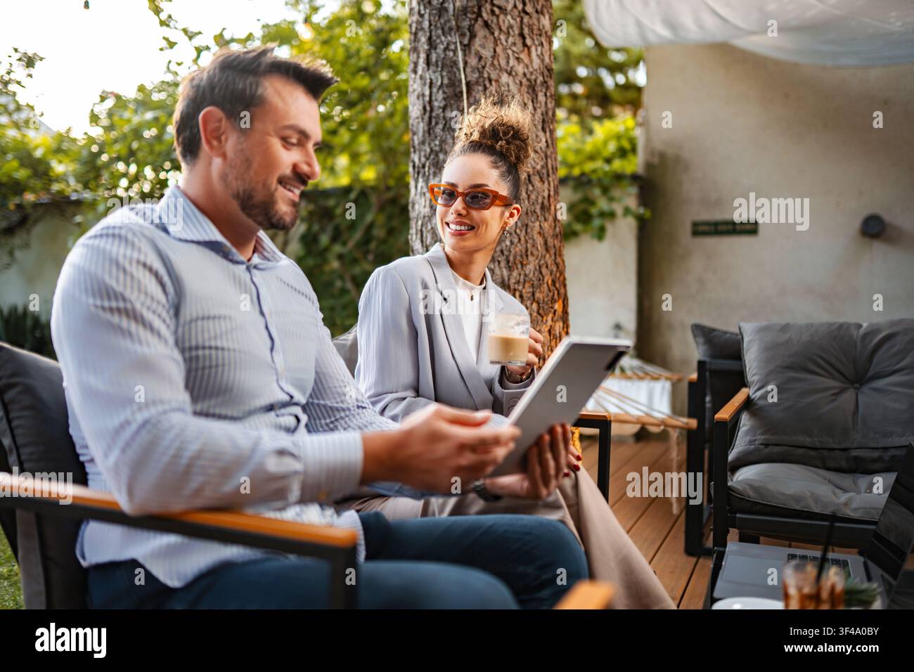 Couple discussing business outdoors using digital tablet Stock Photo