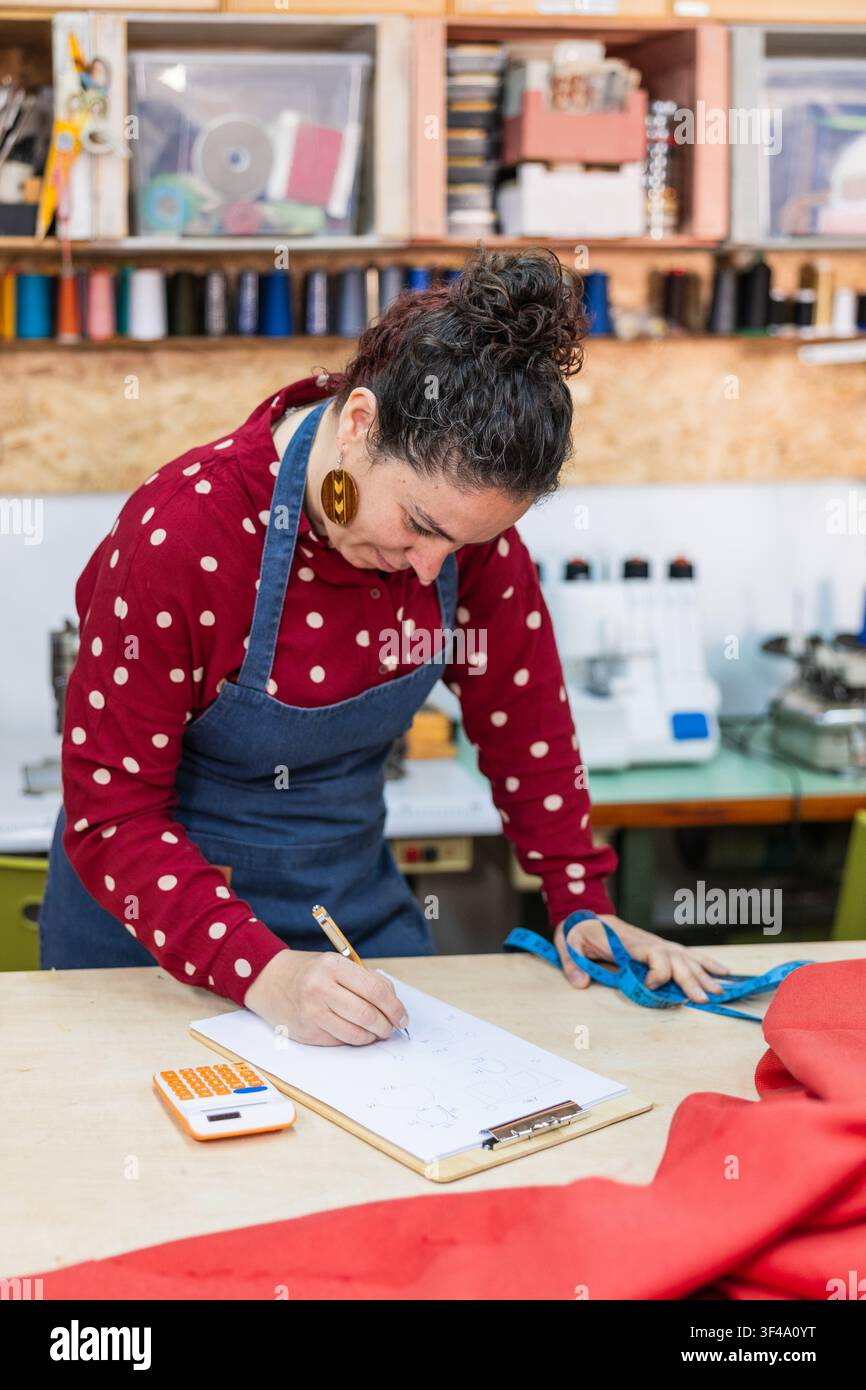 Woman working in tailoring workshop sketching design Stock Photo