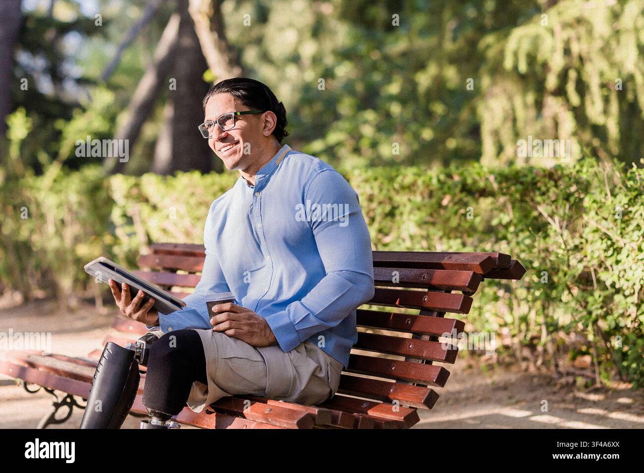 Latino worker with prosthetic leg enjoying park break Stock Photo
