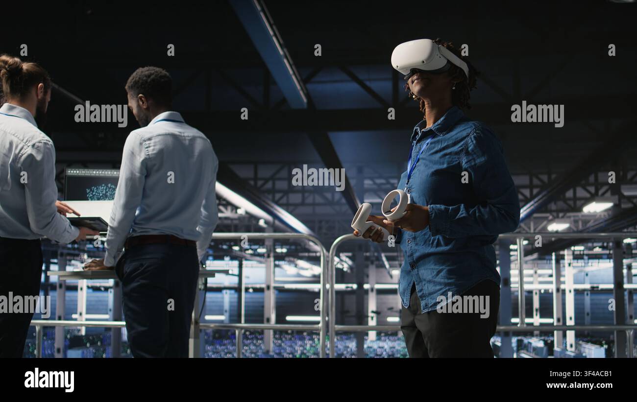 Engineer on data center industrial platform analyzing performance outputs using virtual reality tech. Server hub colleagues finetuning server rig configurations using VR headset tech, Stock Photo