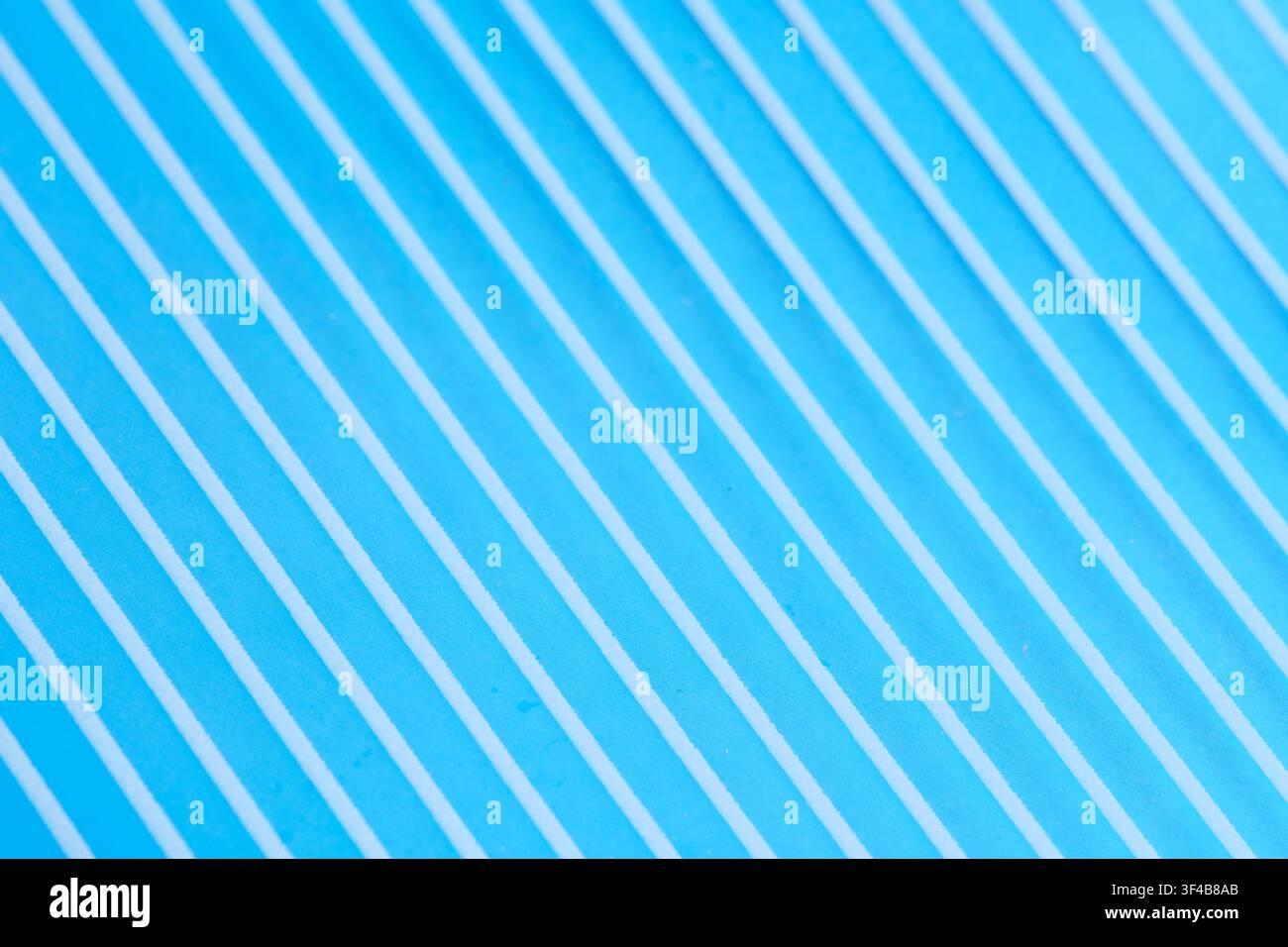 Bright blue textured surface with diagonal parallel white lines creating vibrant modern background Stock Photo