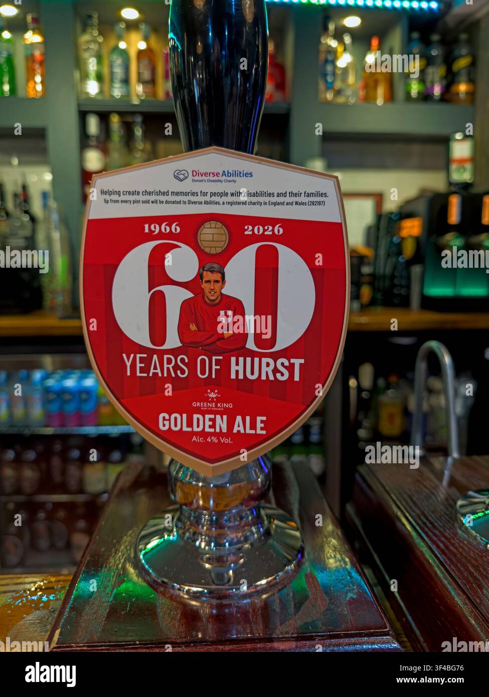 Glass of 60 years of Hurst Golden Ale beer on a bar counter in a British pub. Stock Photo