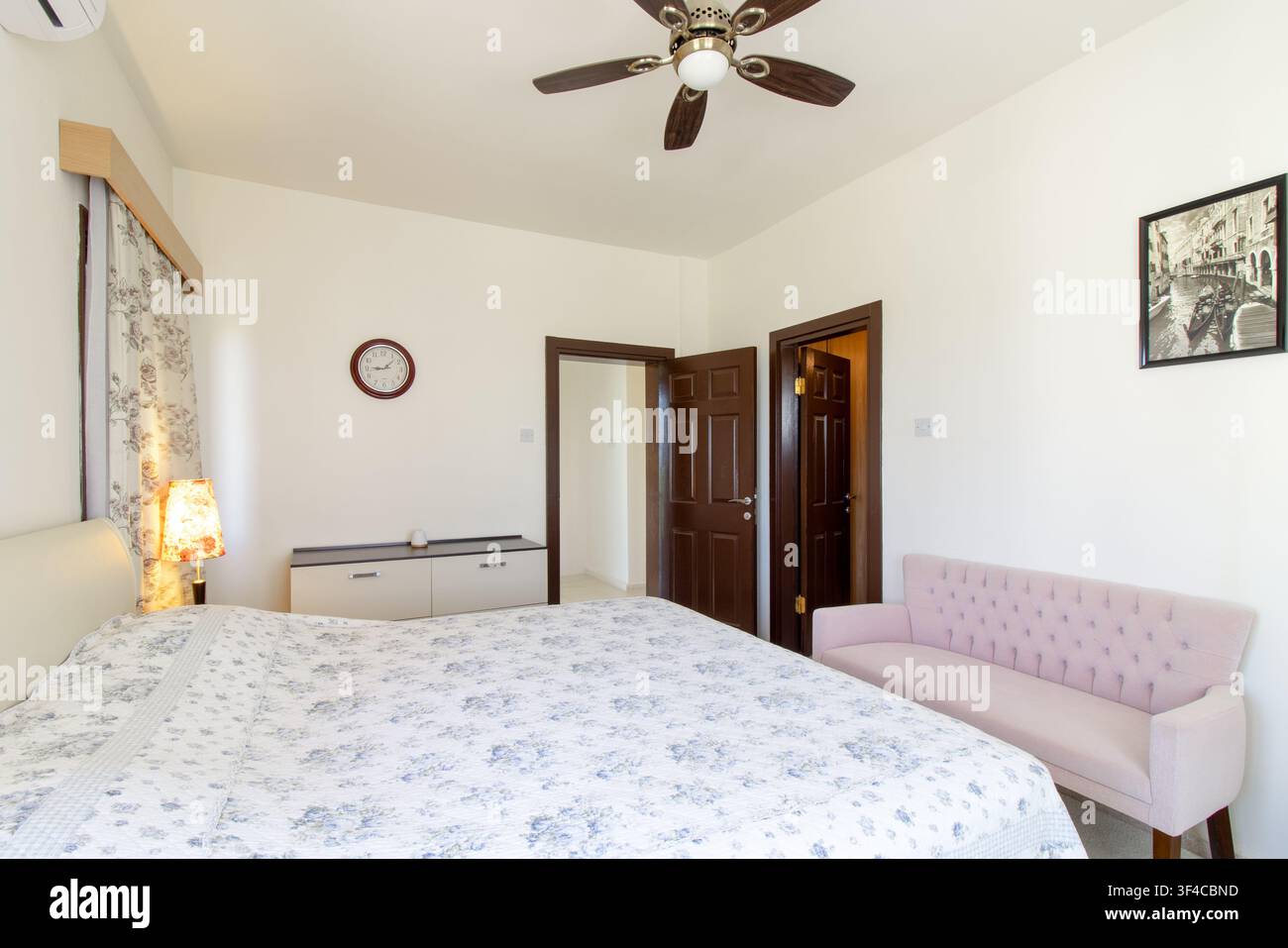 Bright and spacious modern bedroom interior featuring a comfortable double bed Stock Photo