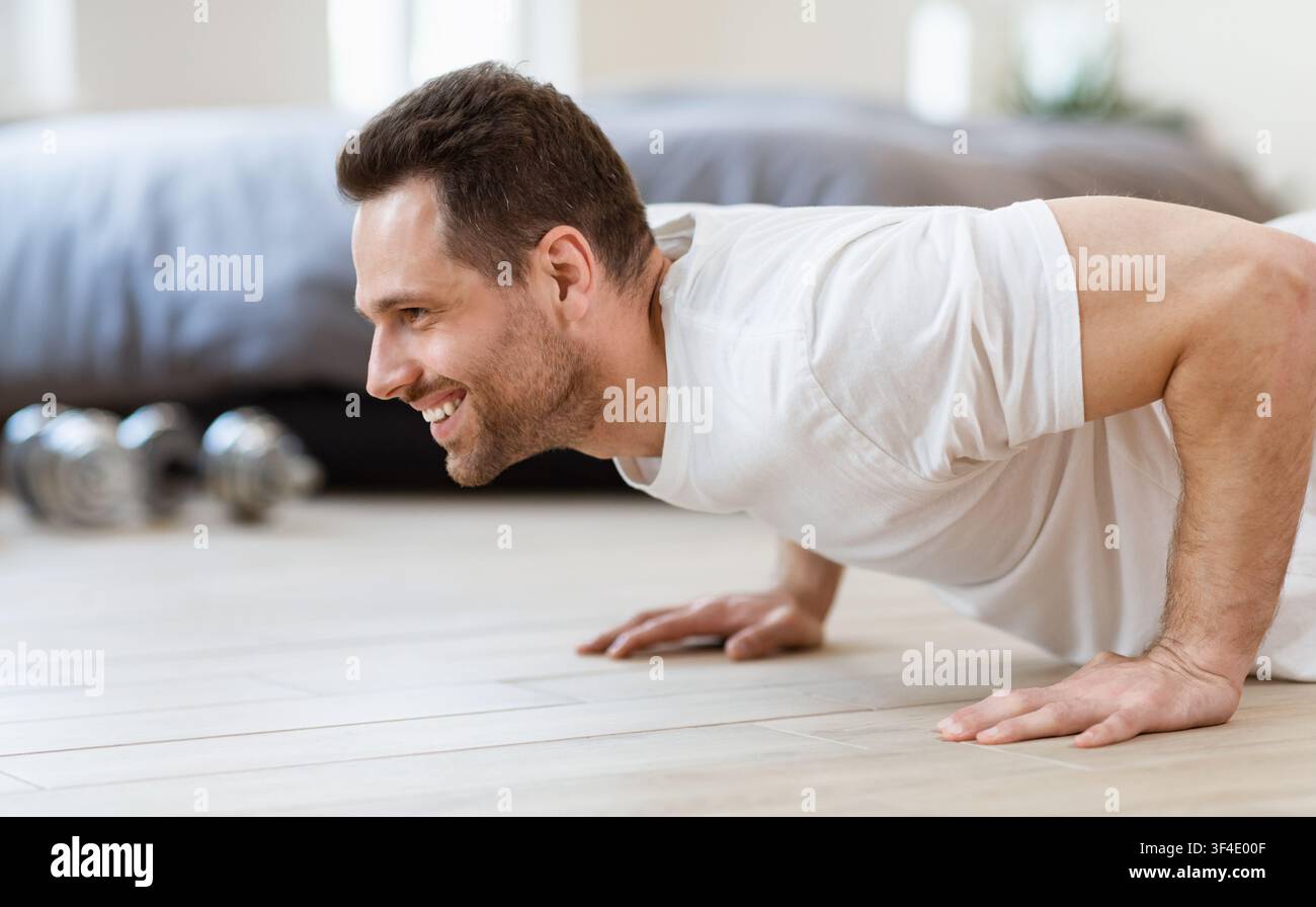 Sporty Man Doing Plank Exercise On Floor Training At Home Stock Photo