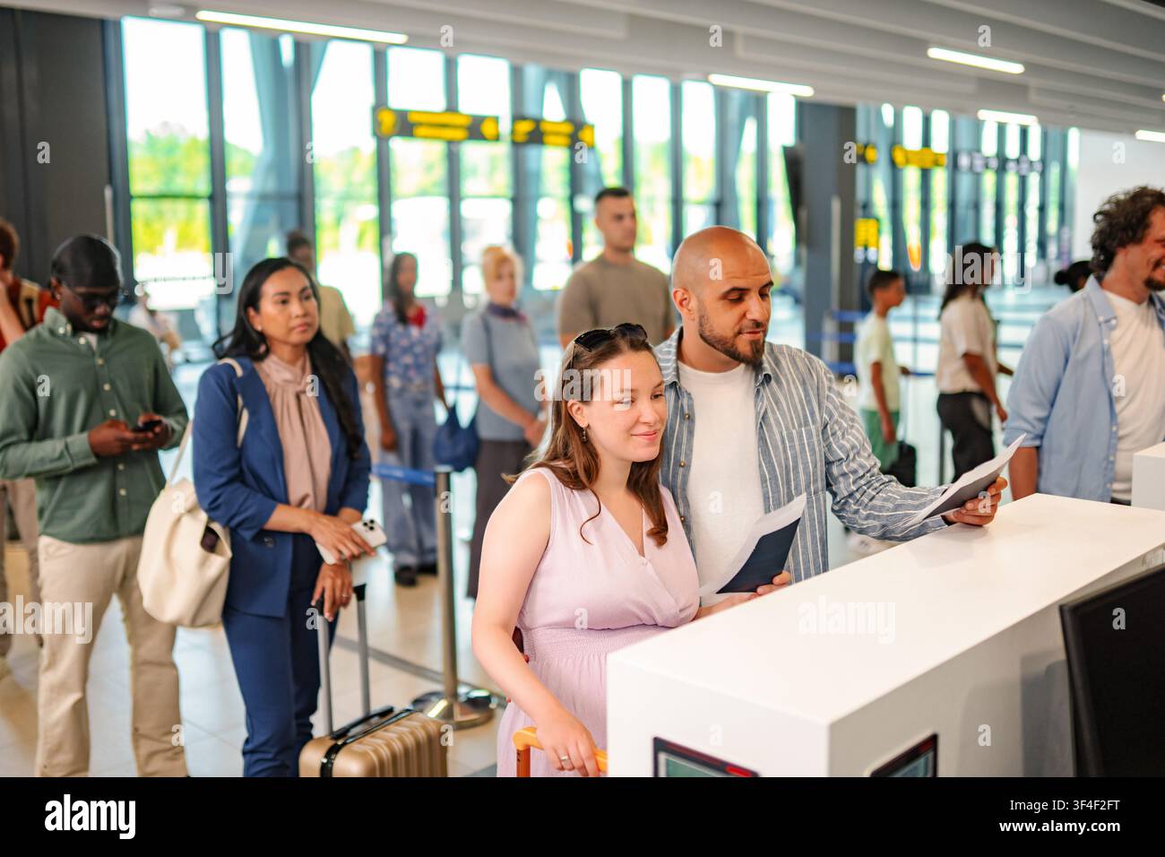 Diverse group of people checking in at airport counter Stock Photo
