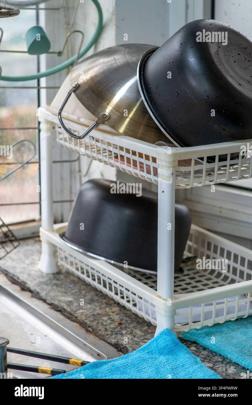 Kitchen utensils drying on countertop near window Stock Photo