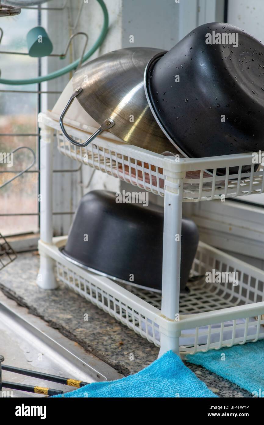 Kitchen drying rack with pots near sunny window Stock Photo