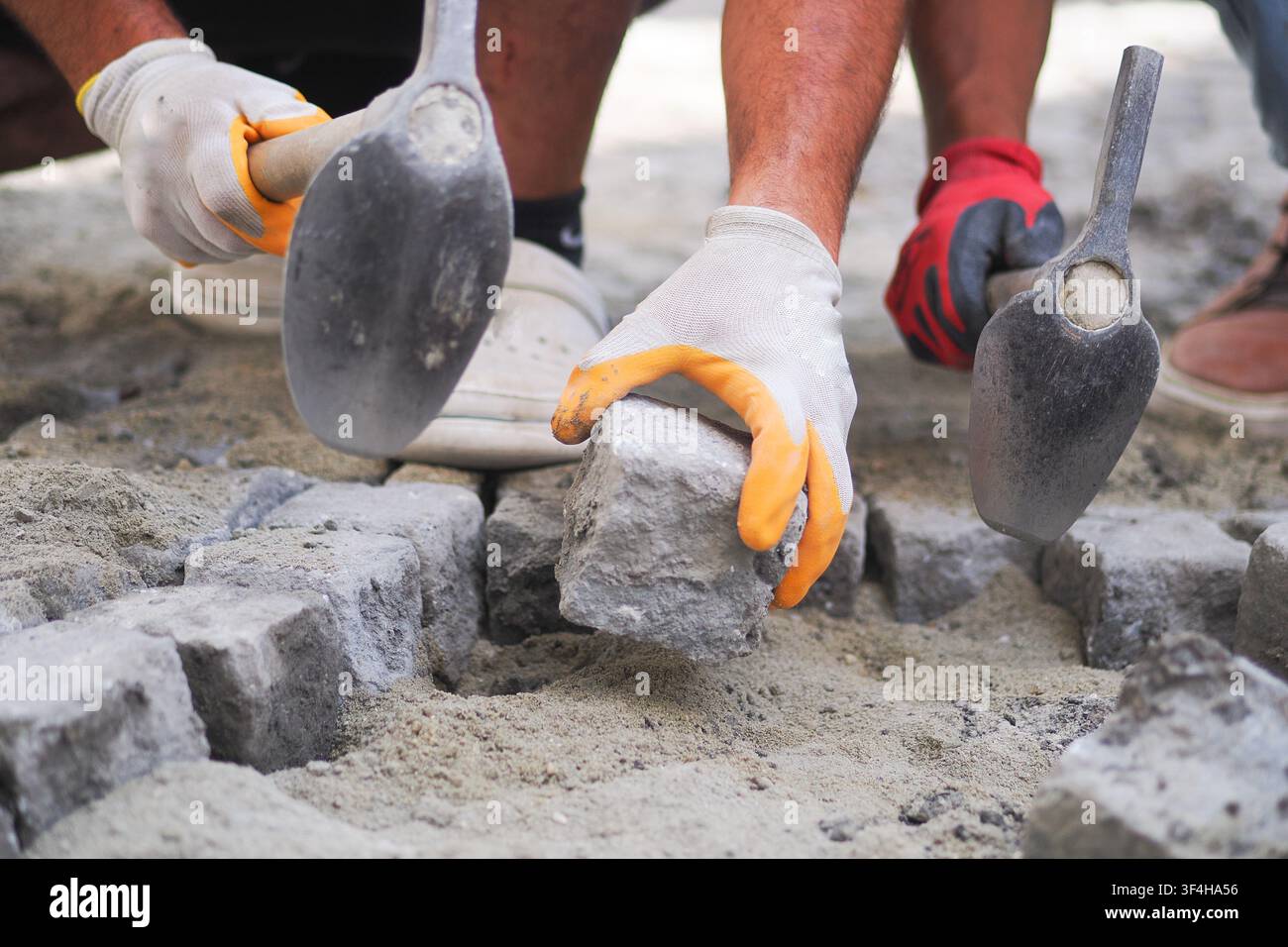 Workers laying bricks on-site in the afternoon Stock Photo