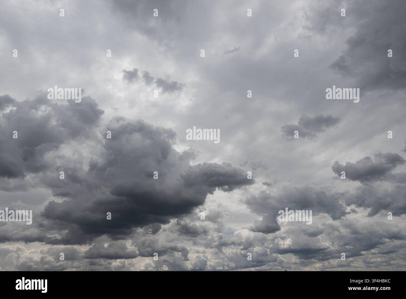 Layered dark storm clouds filling an overcast sky, creating a dramatic grey cloudscape and the sense of approaching rain Stock Photo