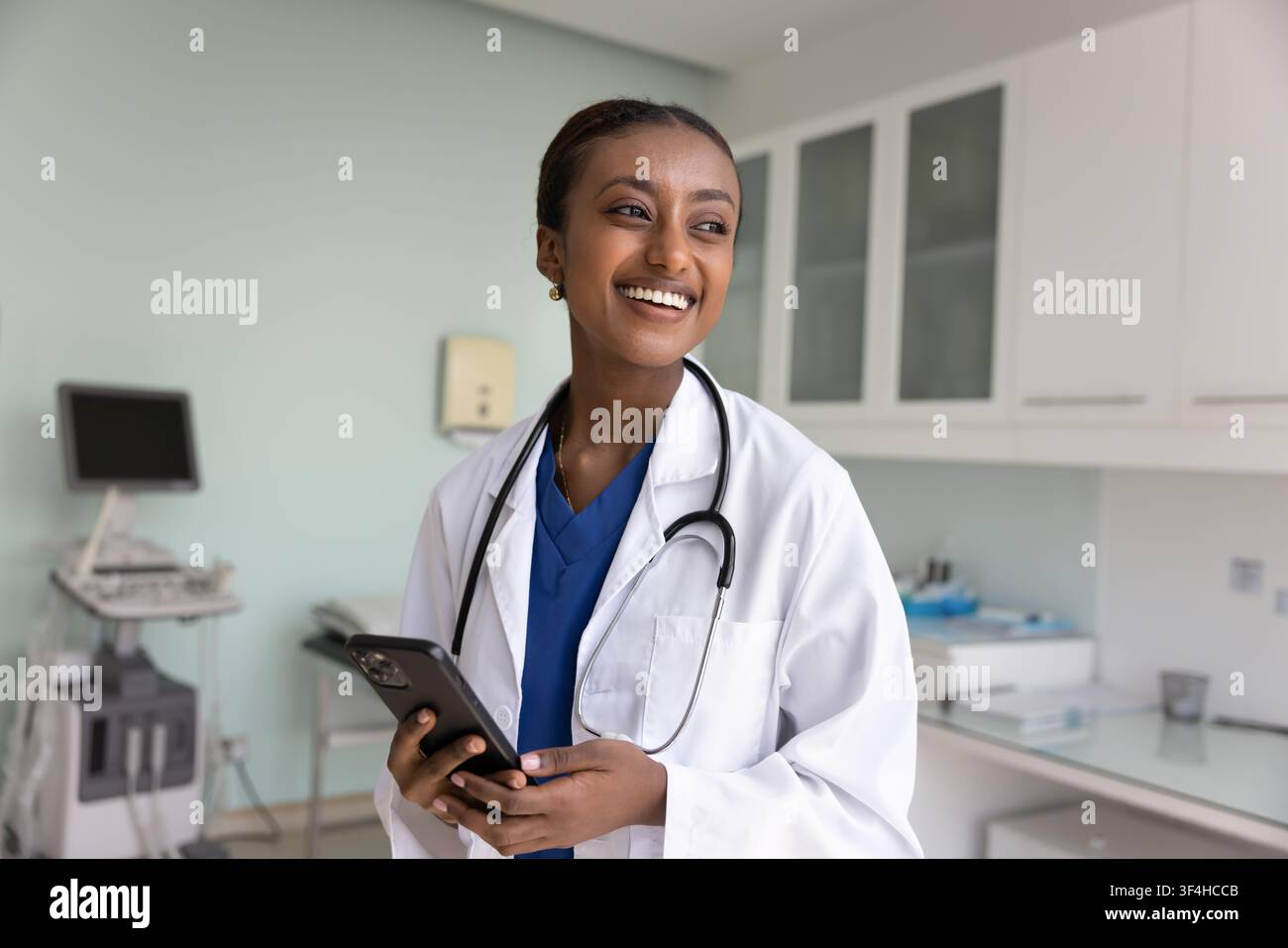 Happy young African American doctor woman using mobile phone Stock Photo
