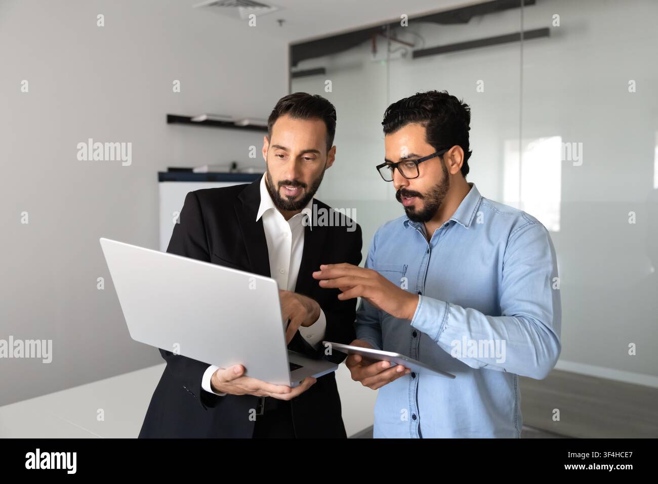 Multiethnic business colleagues working on digital project using laptop Stock Photo