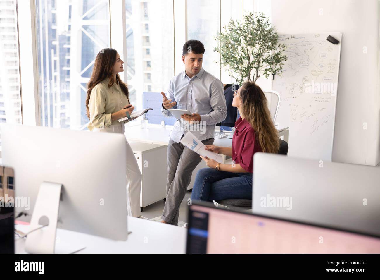 Diverse colleagues engaging in teamwork, collaborating on project in office Stock Photo