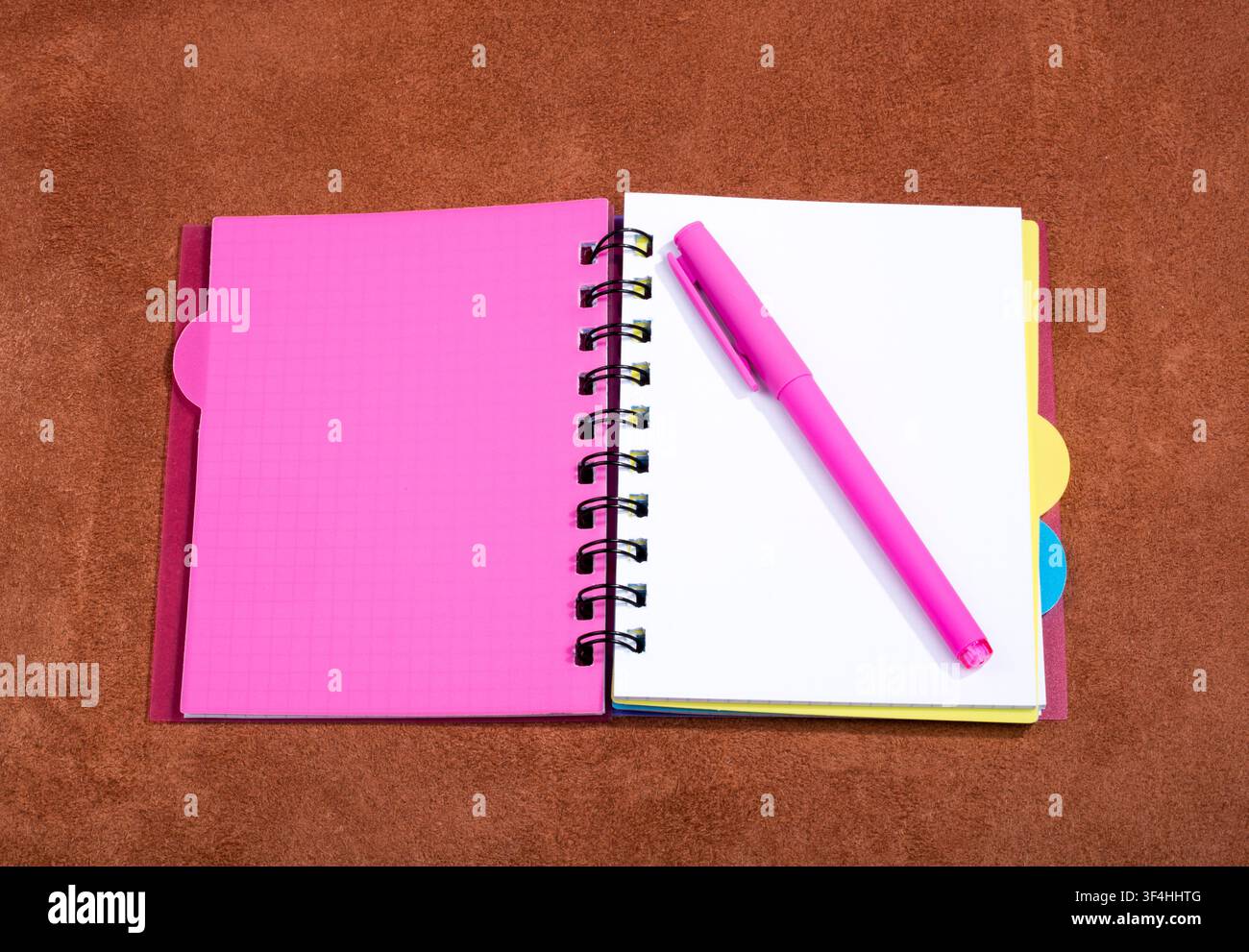 Open notebook with pink bookmark on a pink background Stock Photo