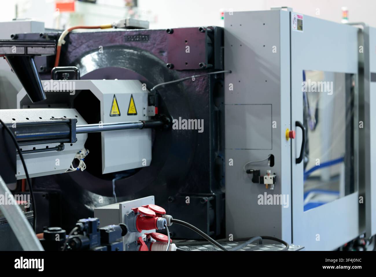 Plastic injection molding machine IMM close up. Selective focus. Stock Photo
