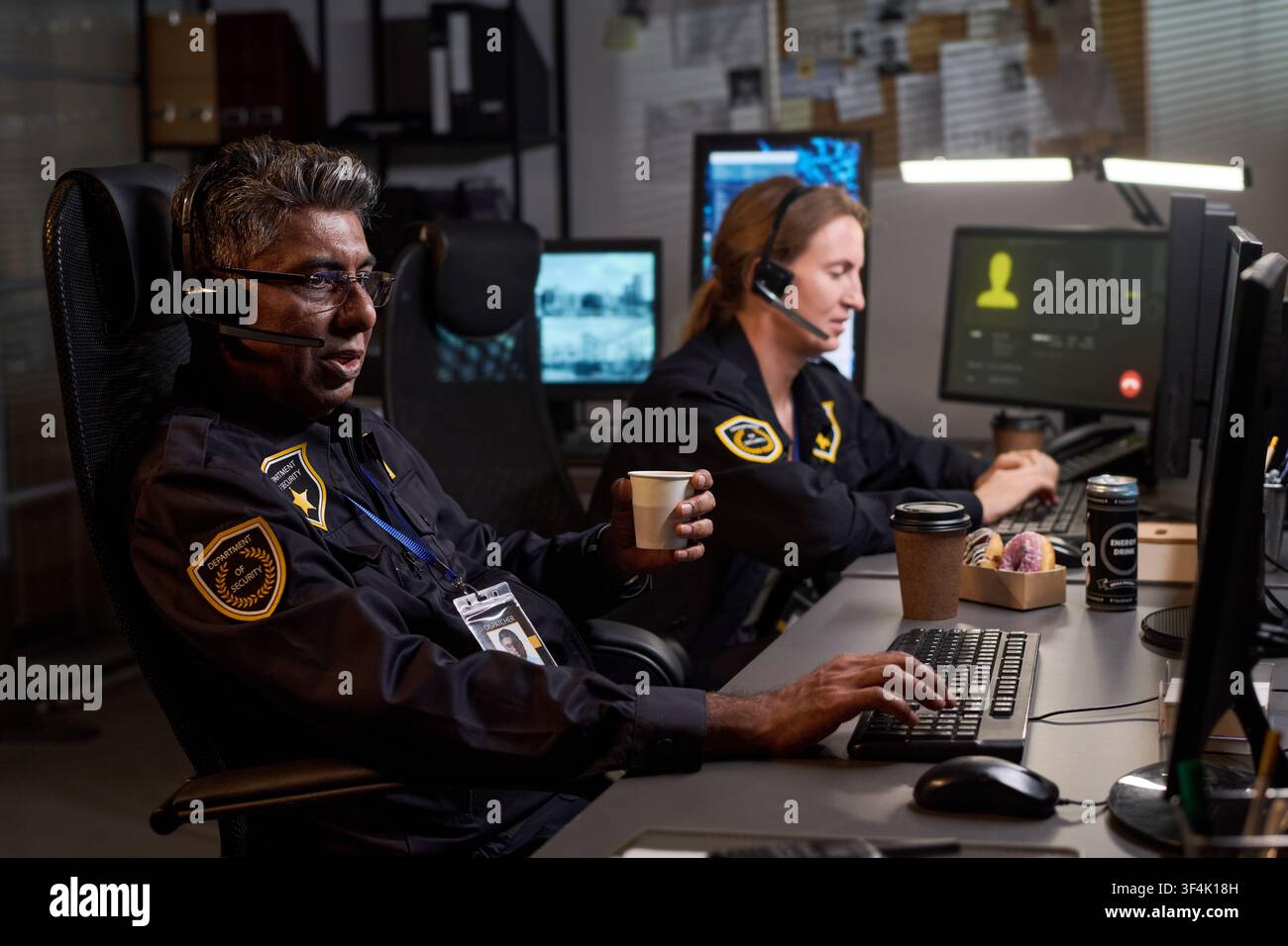 Security Officers Working Overnight in Command Center Stock Photo