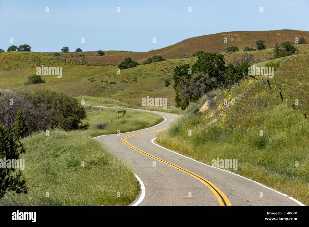 Empty winding road through hills Stock Photo