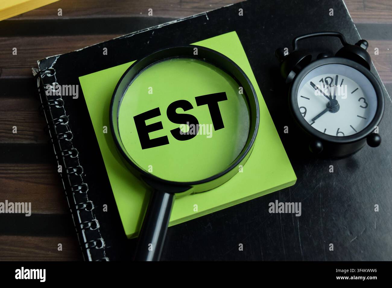 Concept of EST - Earliest Starting Time write on sticky notes isolated on Wooden Table. Stock Photo