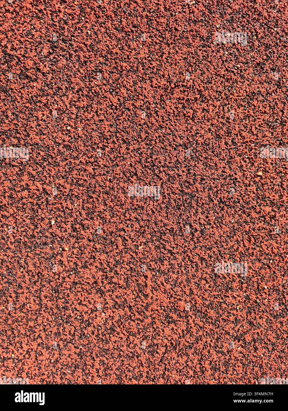 Abstract background of a red rubber running track surface, emphasizing texture, athletic performance, determination and fitness goals. - Smartphone Captured Stock Image