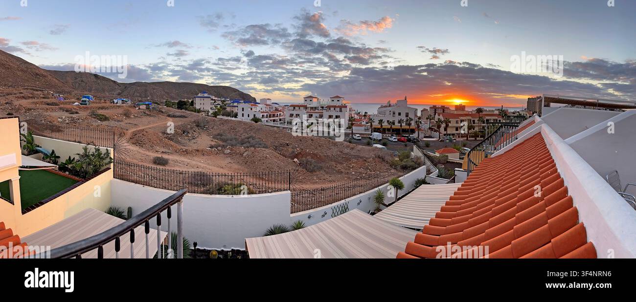 Sunset panorama contrasts holiday villas with a tent encampment on the outskirts of Los Cristianos, Tenerife, Canary Islands, Spain Stock Photo