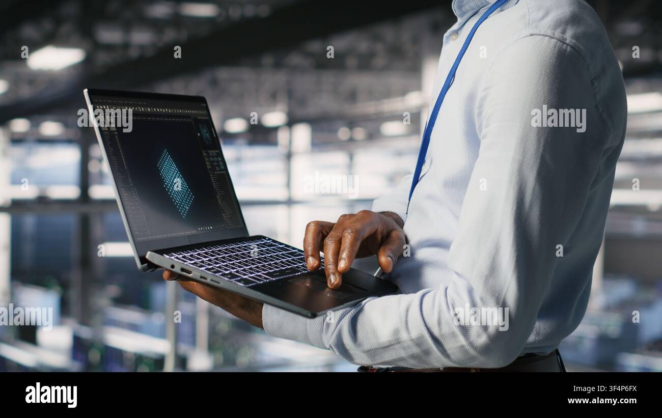 Server hub coworkers visualizing large language model architecture using notebook. Data center technicians on industrial platform collaborating on neural network software tasks using laptop Stock Photo