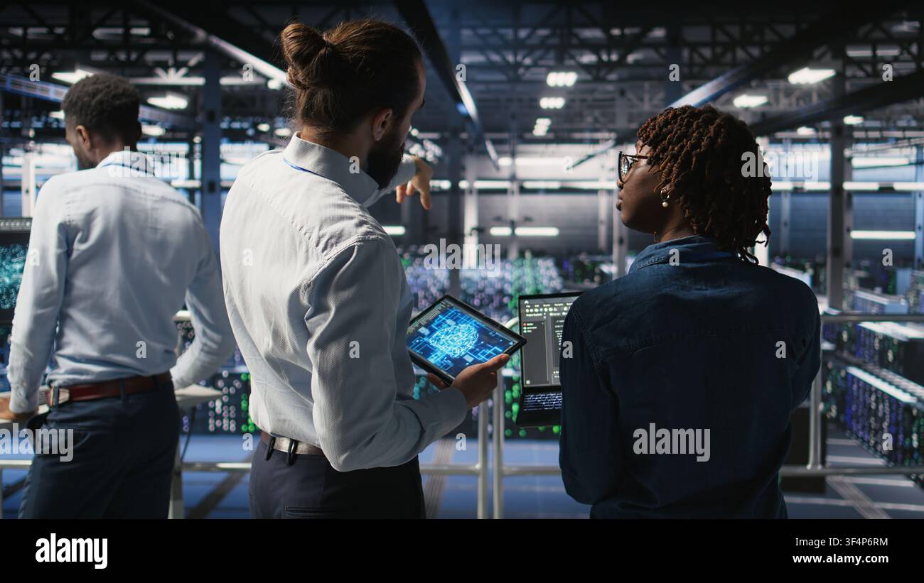 Server farm manager overseeing workers doing infrastructure AI machine learning automatization. Data center team leader supervising employees using artificial intelligence, Stock Photo