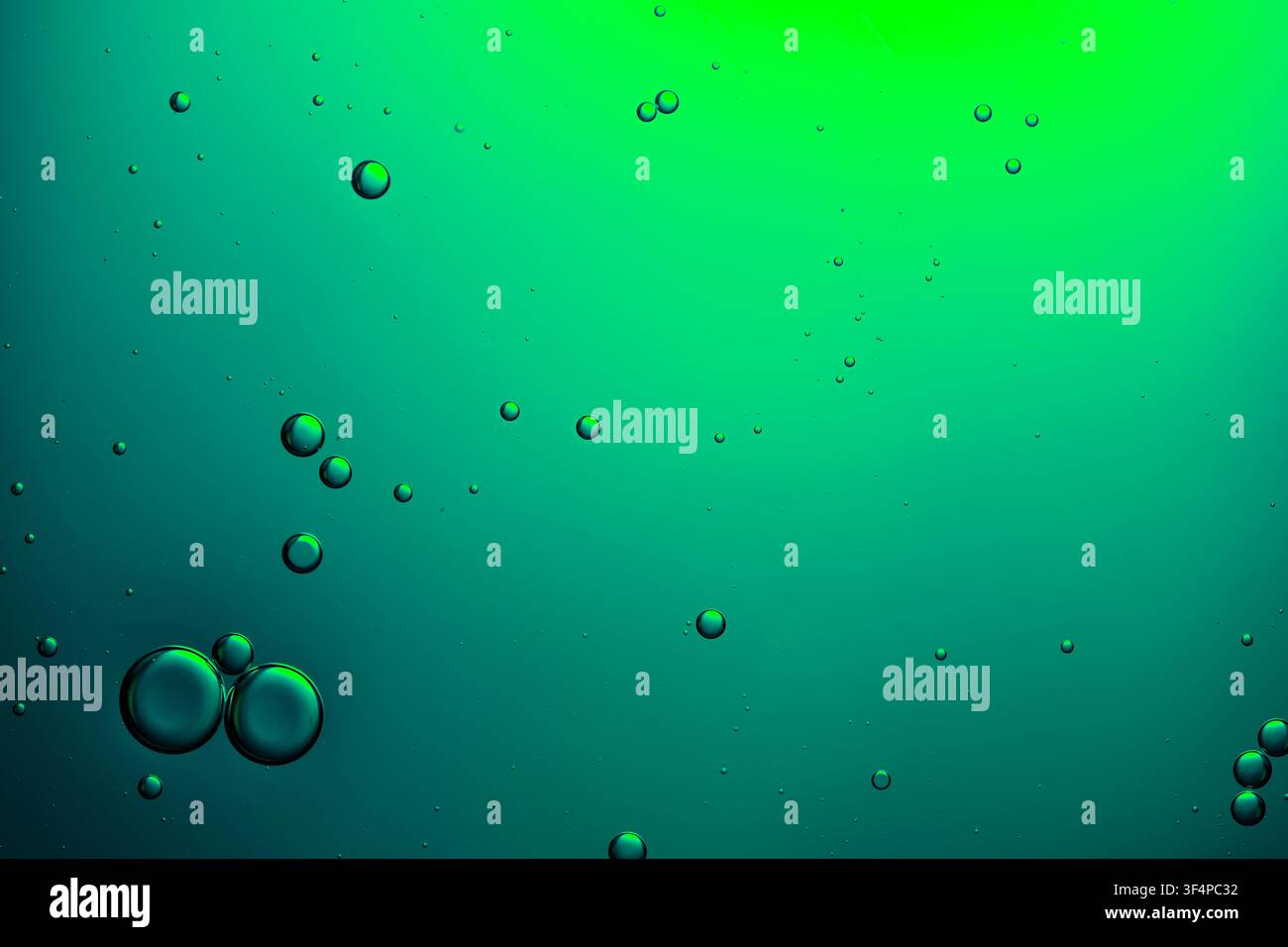Bubbles creating an abstract pattern in green liquid, forming a vibrant background Stock Photo