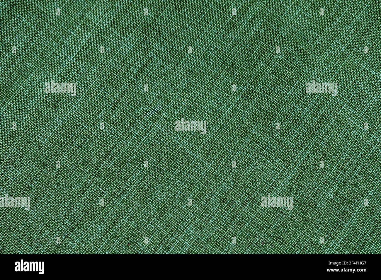 Green woven fabric texture photographed in close-up, ideal as a seamless-looking textile background. Stock Photo