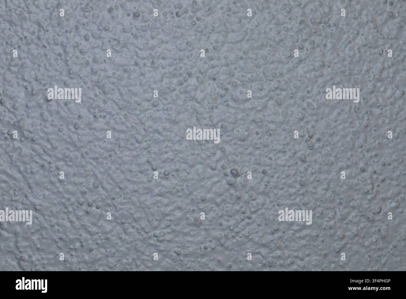 Neutral gray textured surface with a fine rough pattern, suitable as a background or abstract texture. Stock Photo