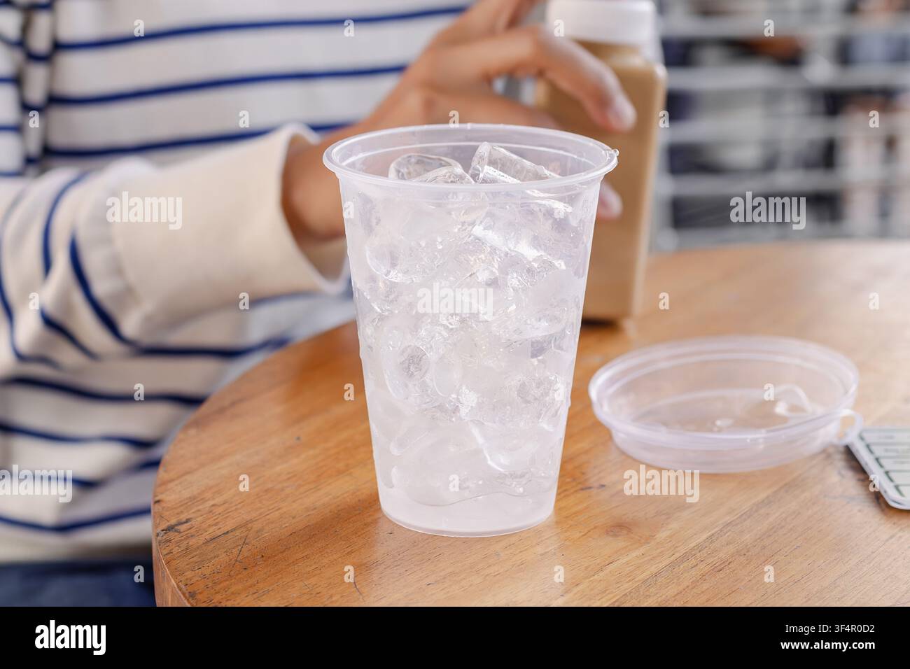 A cup of ice cubes on a table in a cafe Stock Photo