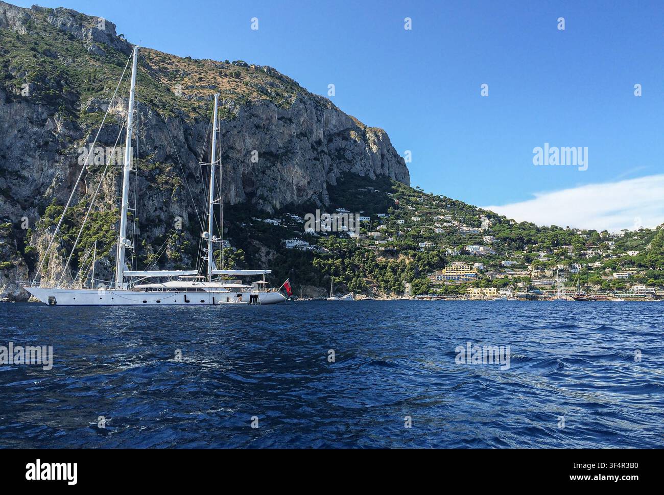 The luxury sailing yacht ROSEHEARTY lies at anchor beneath Capri’s iconic cliffs, Italy, former yacht of famoux businessman Rupert Murdoch - Smartphone Captured Stock Image