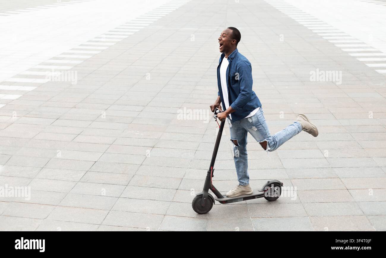 Guy having pleasant ride on electric kick scooter Stock Photo