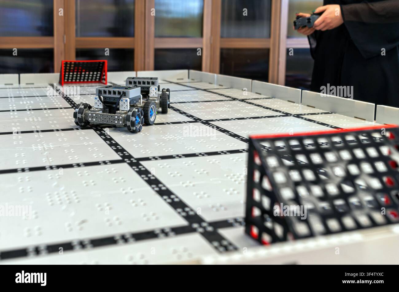 Small robots compete in a technology display at a robotics event in a classroom setting Stock Photo