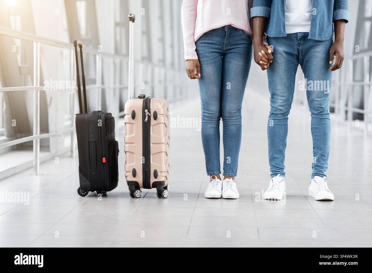 Travelling Together. Black Couple Holding Hands While Standing In Airport Corridor, Cropped Stock Photo