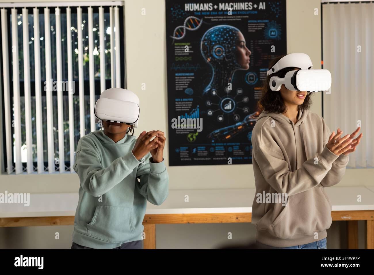 African American youths wearing hoodies and VR headsets interacting with AI poster at lab bench Stock Photo