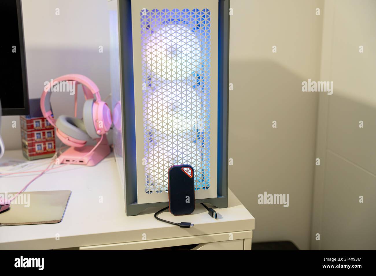 Personal computer with RGB lighting and external SSD connected on a modern desk setup Stock Photo