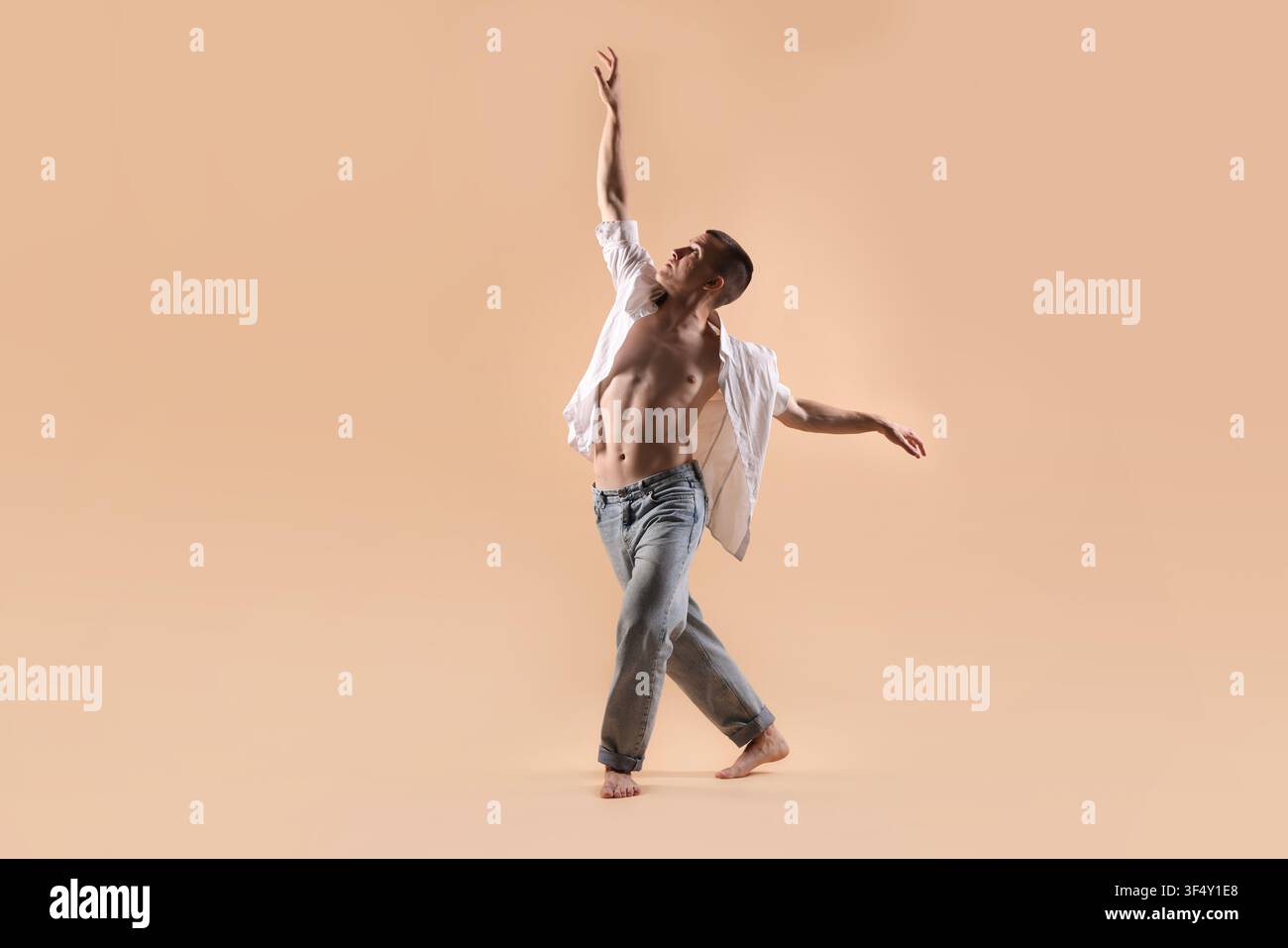 Professional dancer practicing moves on beige background Stock Photo
