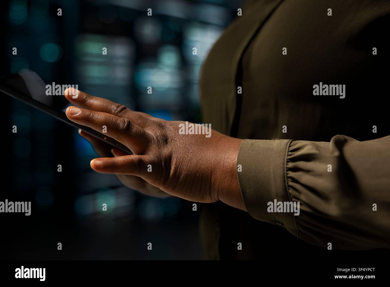 Close up of programmer using touchscreen device to do maintenance in data center with setup helping companies stay connected. IT expert walks with tablet between server hub machines blinking lights Stock Photo