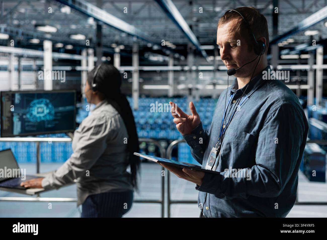 Team of data center colleagues using headset mic, interpreting AI logs to resolve clients issues. Technicians identifying hardware issues using predictive artificial intelligence alerts, guiding users Stock Photo