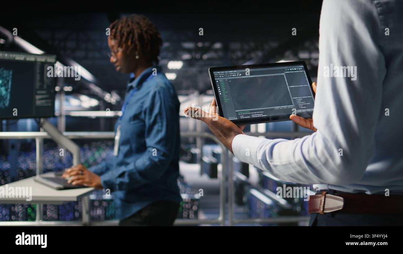 Close up of data center programmer looking at code debugging tools running on tablet. Server farm IT professional checking machine learning script automating tasks, Stock Photo