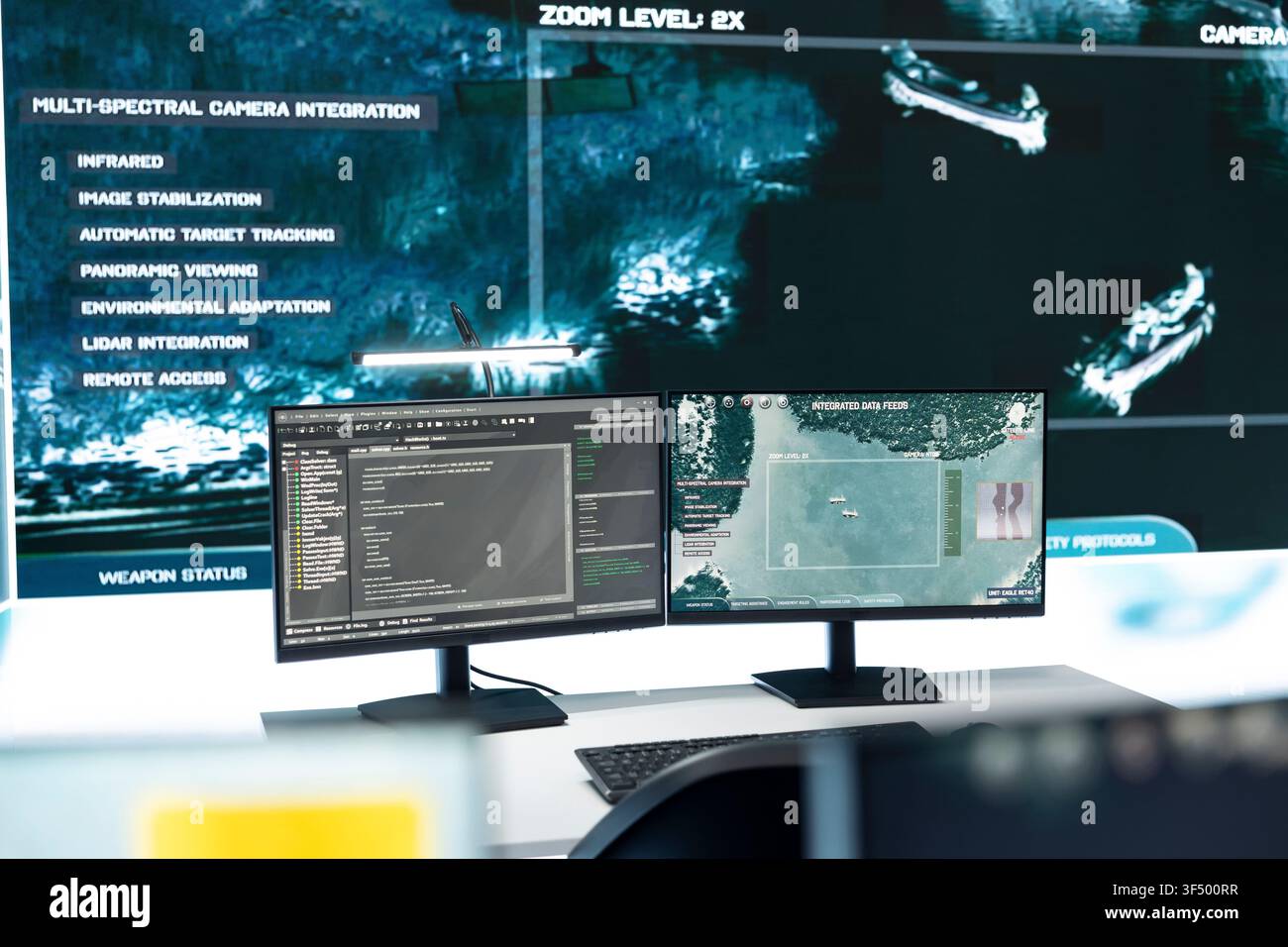 Military command post workstation with computer screens displaying satellite surveillance software. Intelligence system monitors defensive operation data inside empty control room, close up Stock Photo