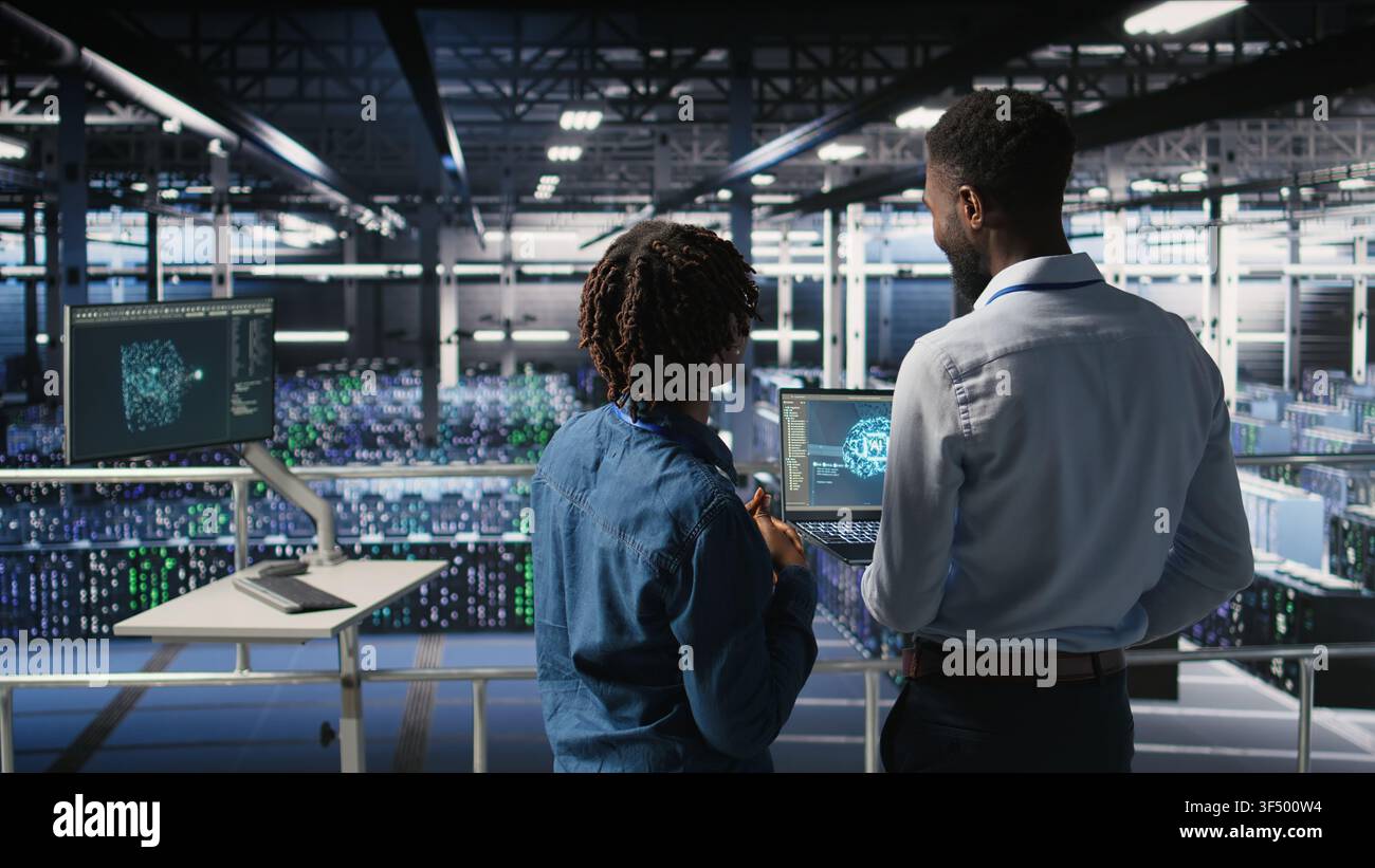 Data center team on industrial platform collaborating to maintain servers using artificial intelligence. Engineers cooperating to support infrastructure AI machine learning automatization, Stock Photo