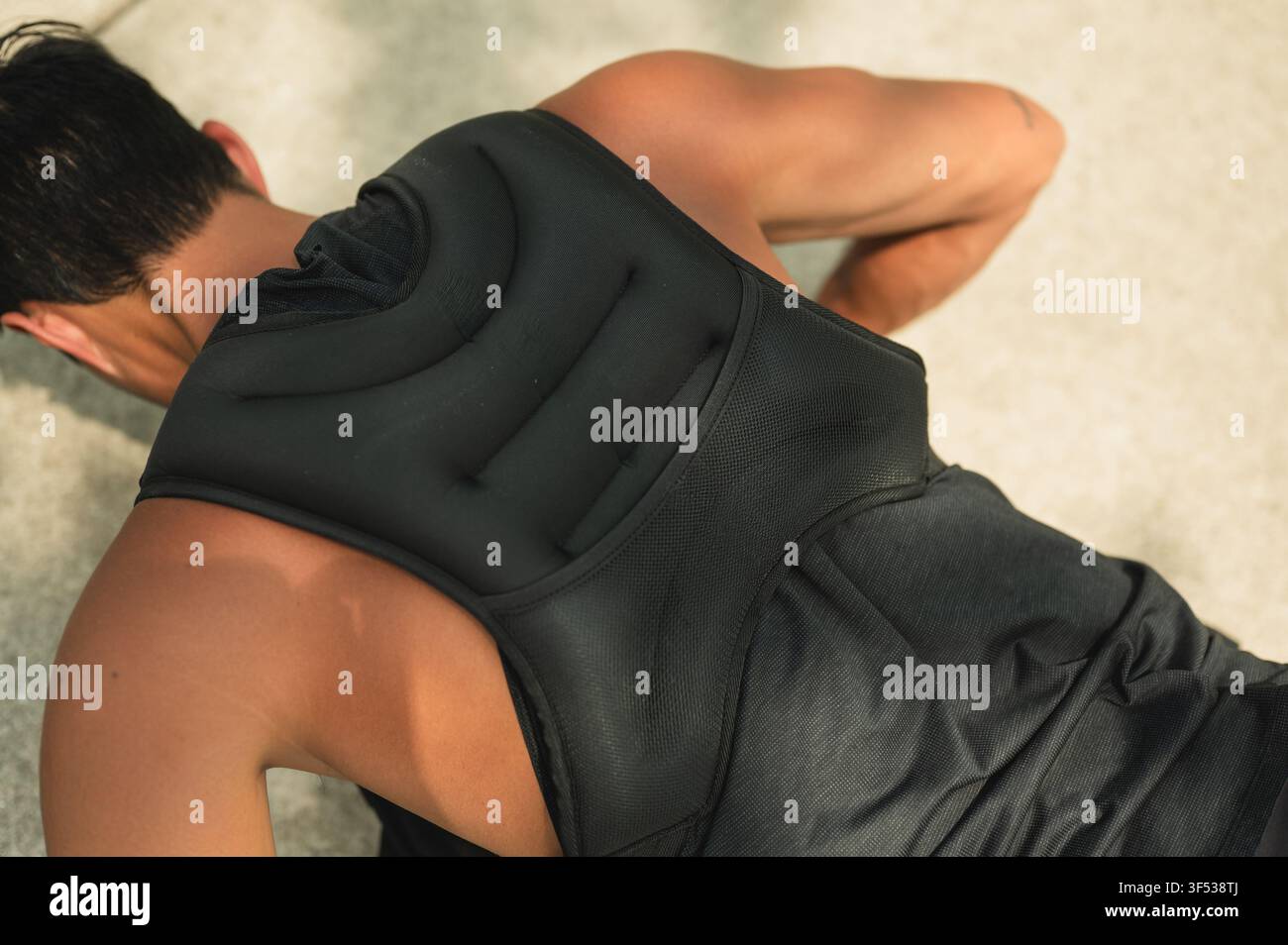 Man doing push ups while wearing a weighted vest Stock Photo